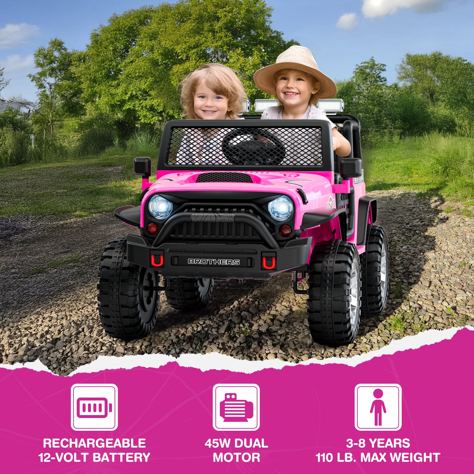 Two children in a pink toy ride-on car on a dirt road with greenery in the background.